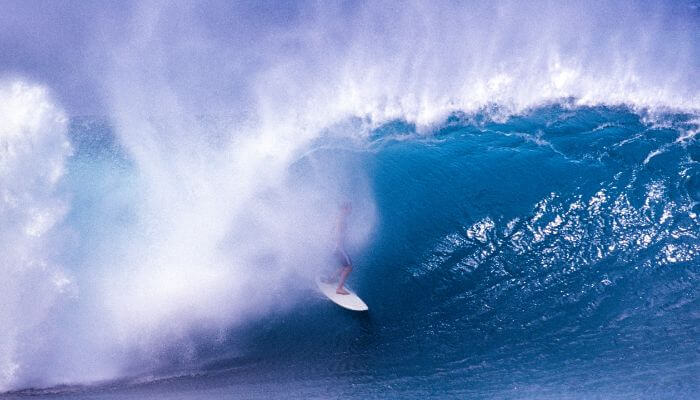Surfista executando uma saída de tubo espetacular em Banzai Pipeline, destacando habilidade e controle nas famosas ondas havaianas. Com certeza vai ajudar nos Critérios de Julgamento no Surf.